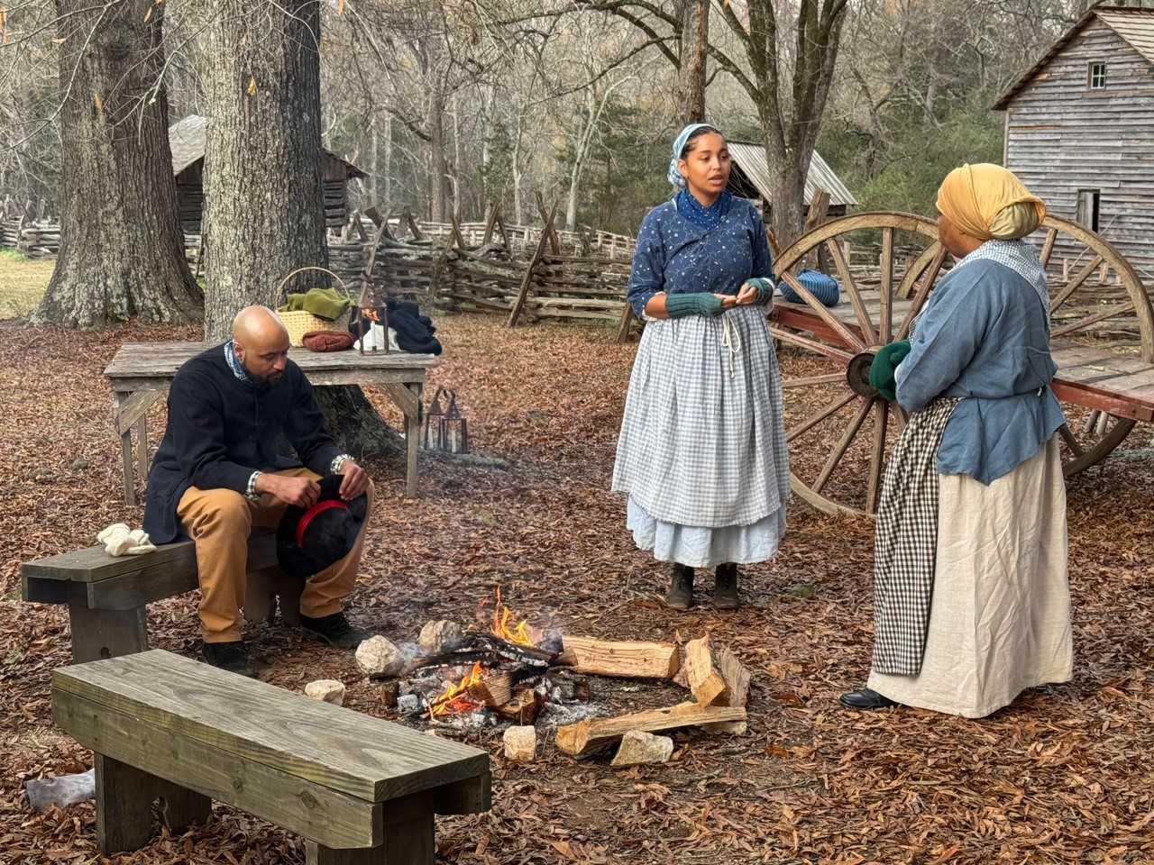 18th century dressed African Americans around a camp fire